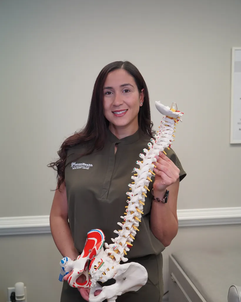 Dr. Soammy Matias, D.C., holding a spine model at Matias Health Chiropractic in Roswell, Georgia